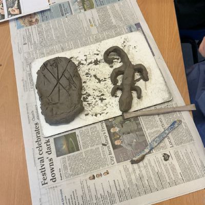 Children making clay lizards